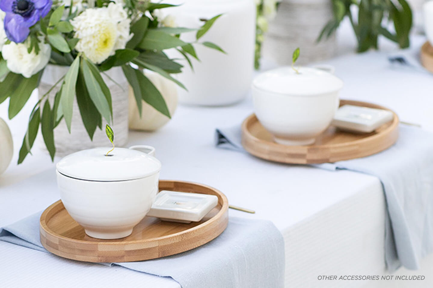 Table setting for a wedding shower with Café Cups, Oval Trays and Tea Trays in a row with flower arrangements. Photo by @SugarAndCharm 
