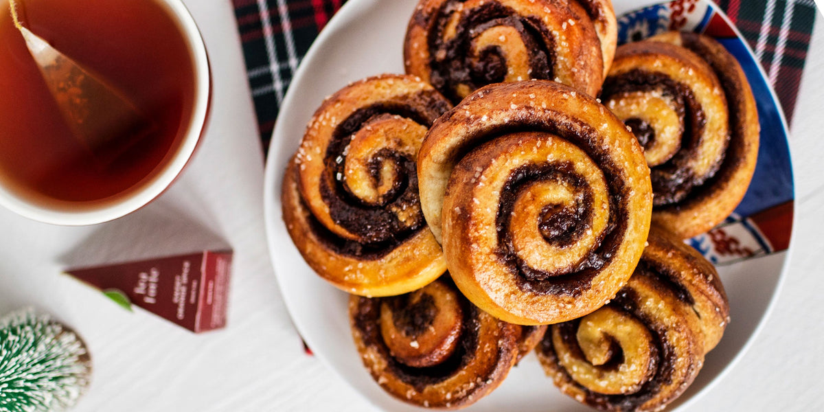 Choclate Orange Sweet Rolls on a plate with holiday tea on white table