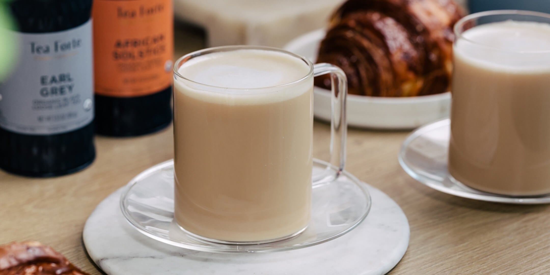 London Fog Latte on table with Loose tea canisters