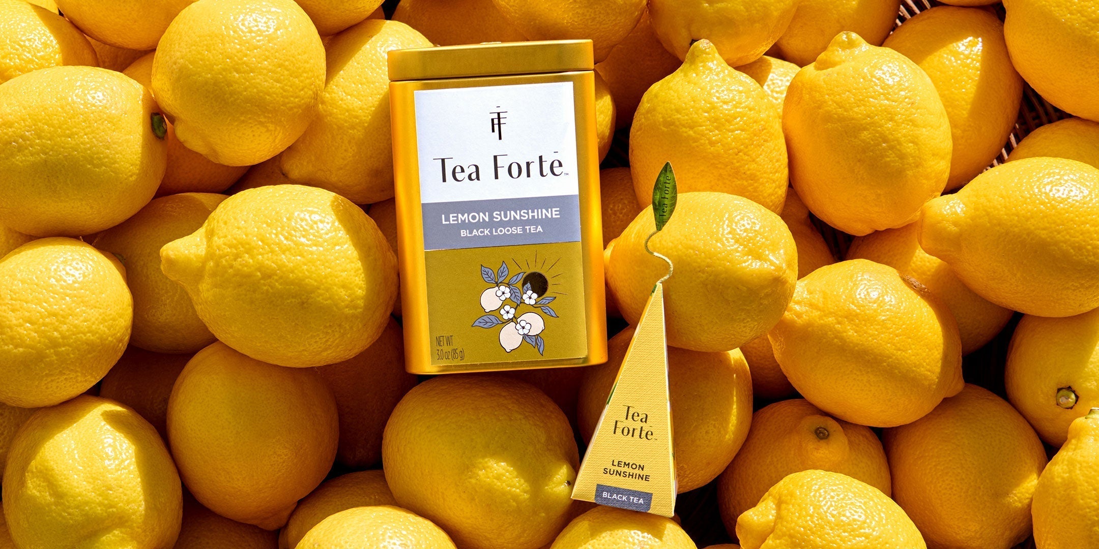 Lemon Sunshine Loose tea and infuser on a pile of yellow lemons
