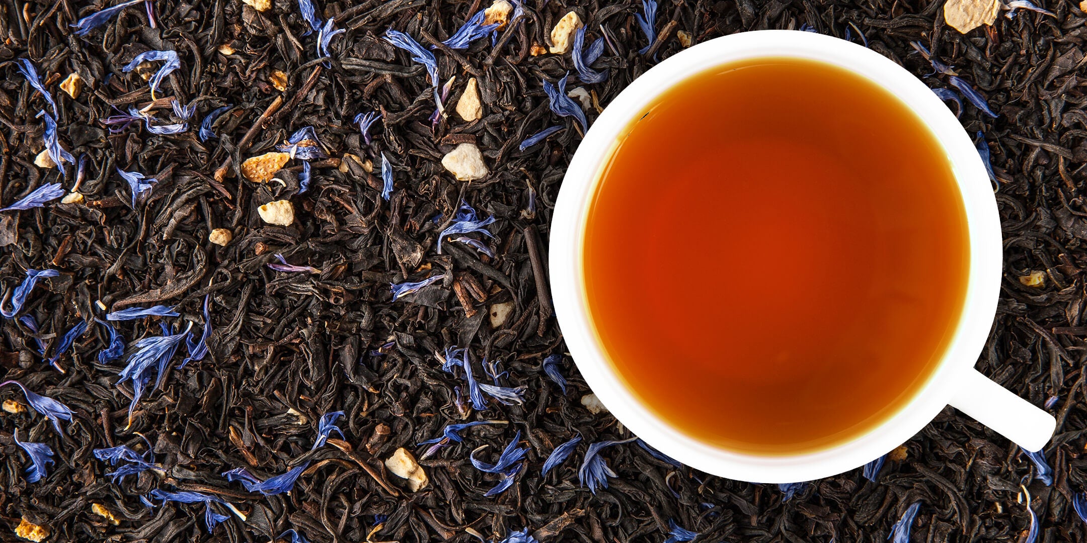 Earl Grey tea in cup on top of loose leaf tea