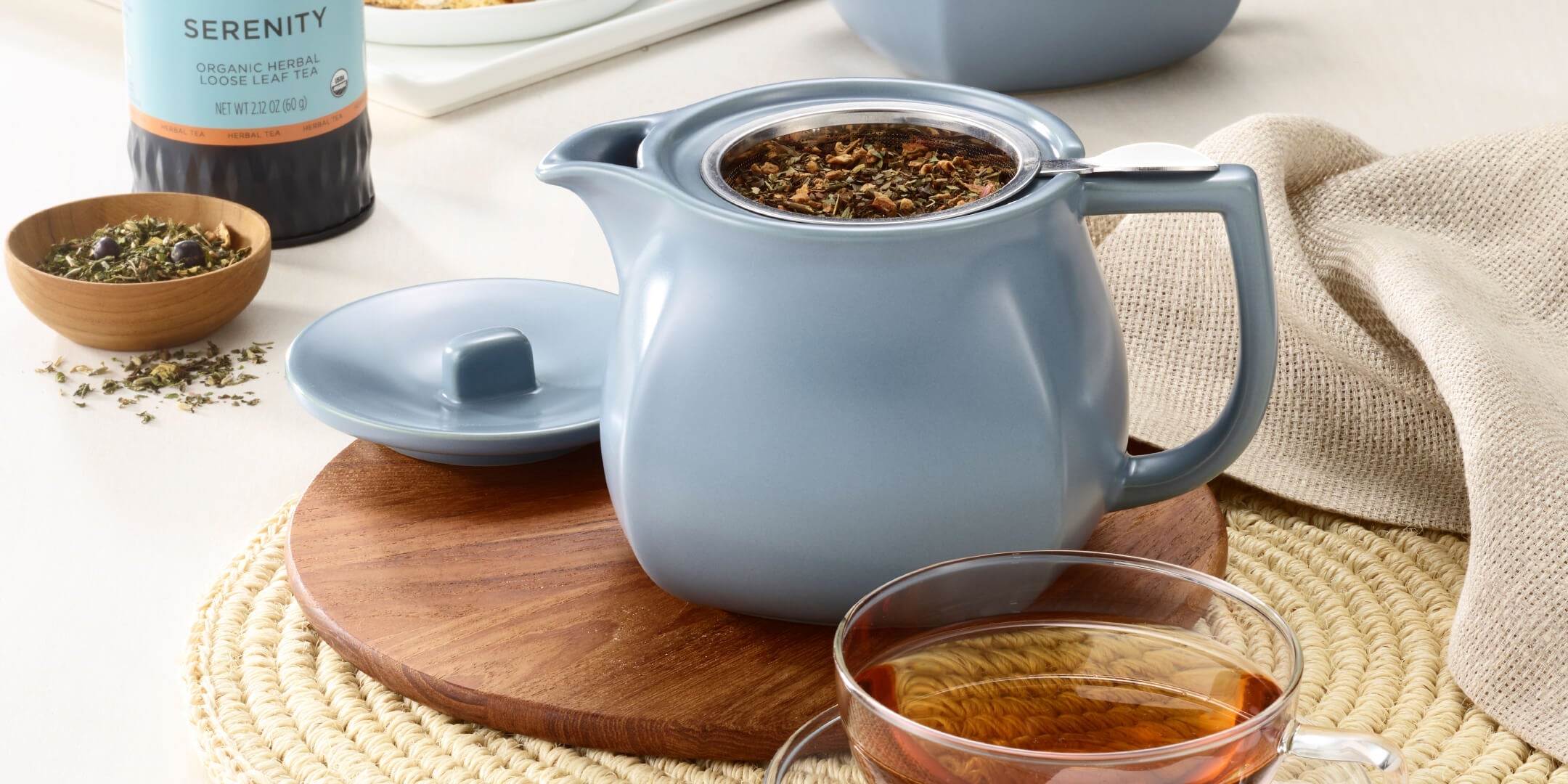 Fiore Stone Blue Teaware, teapot with lid off, loose tea canister in the background