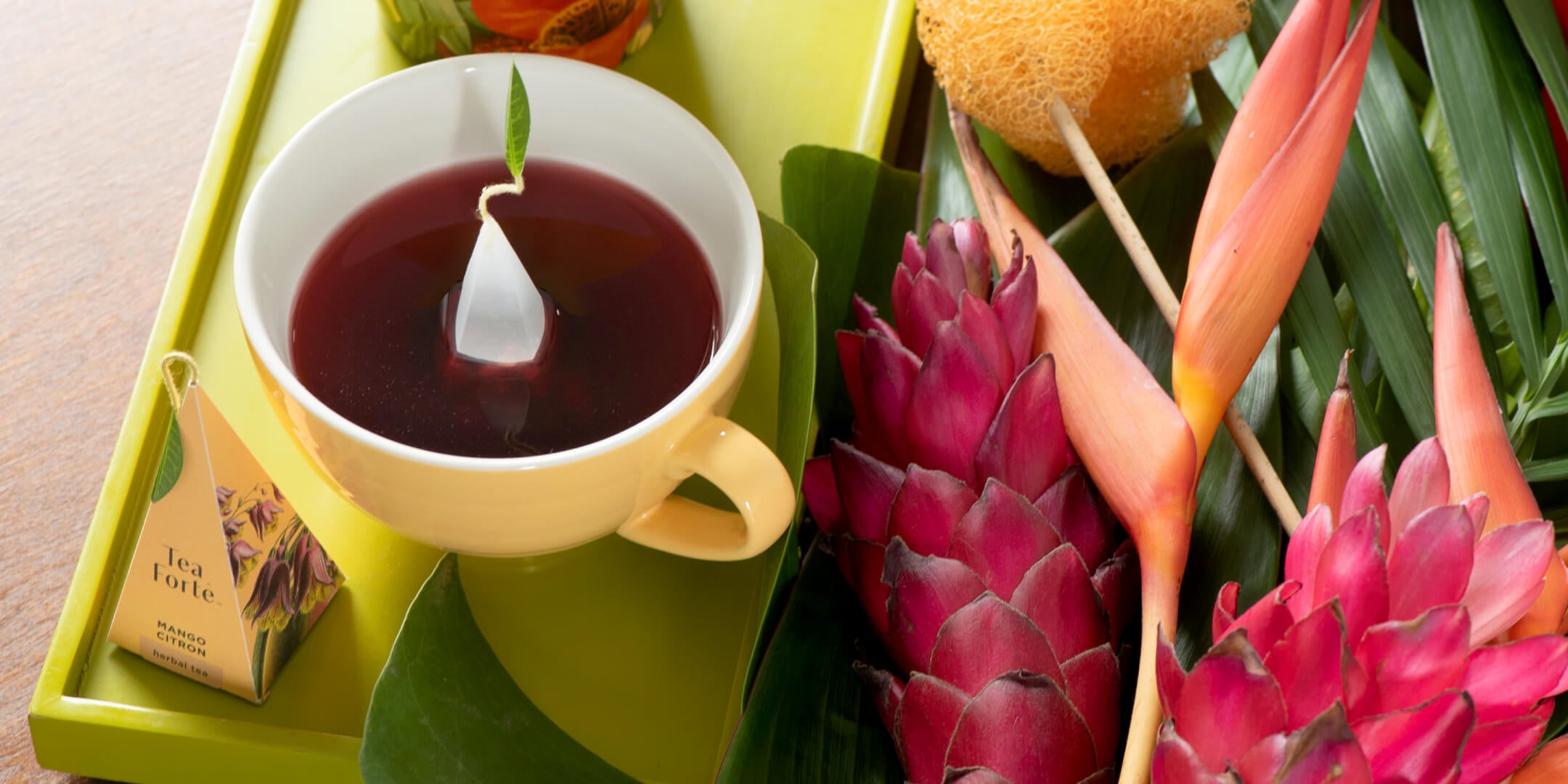 Cup of mango Citron tea with infuser and flowers