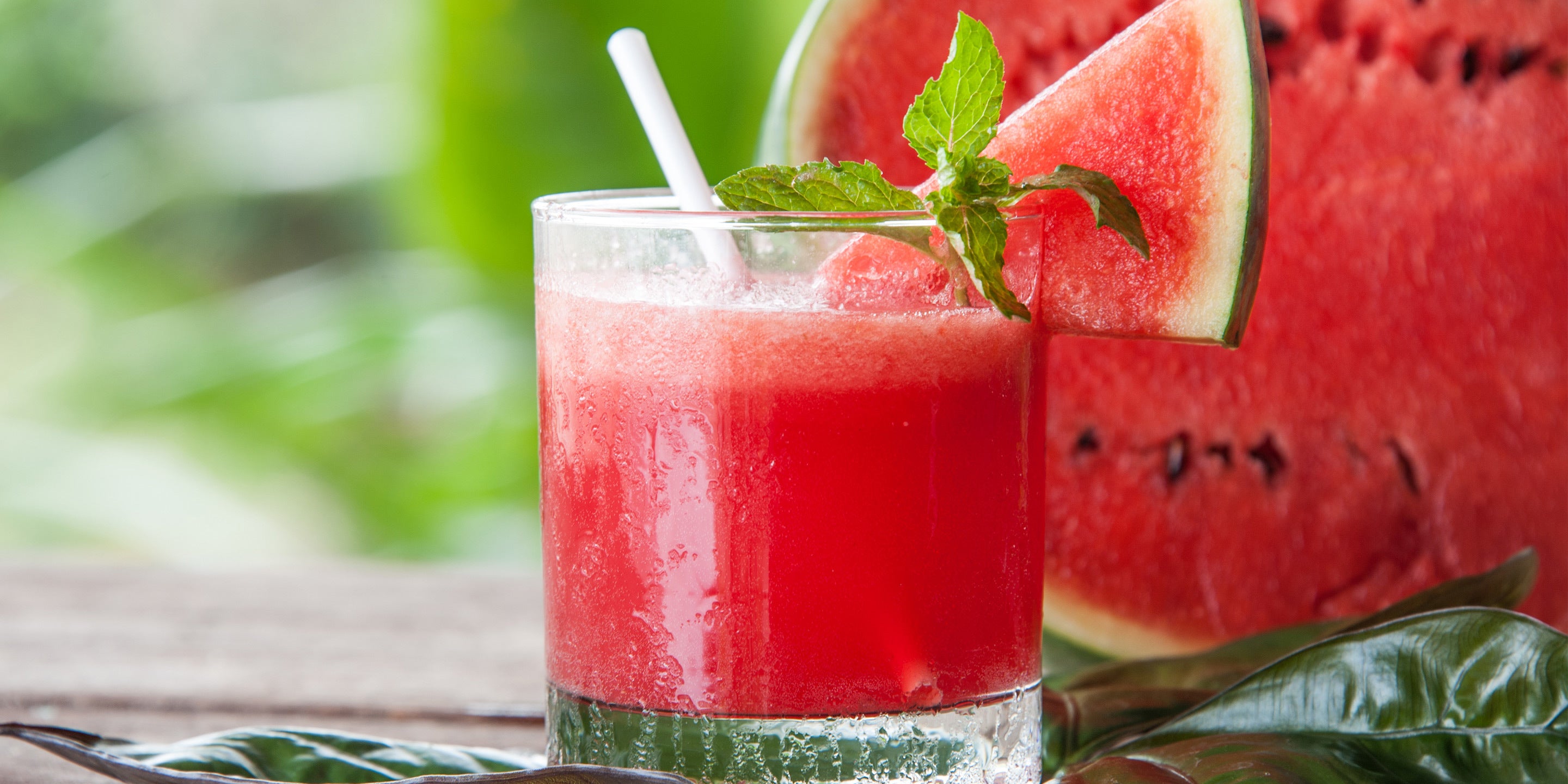 Glass of Raspberry Watermelon Iced Tea with watermelon in the background