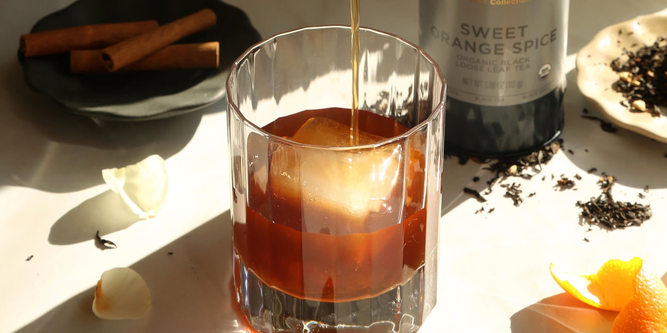 Spiced Citrus Sparkling Negroni with a loose tea canister of Sweet Orange Spice