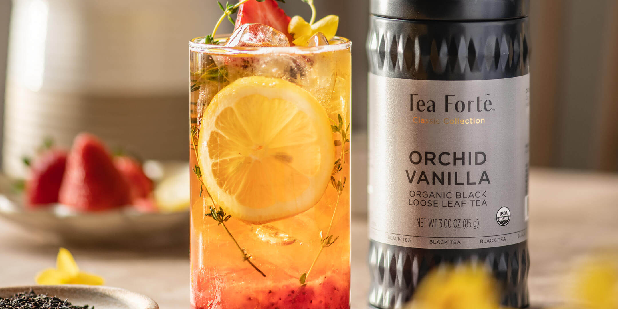 Strawberry Vanilla Iced tea in a glass with Orchid Vanilla Loose Tea Canister