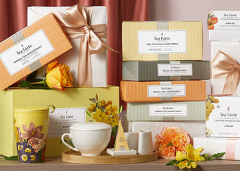 Various Petite and Presentation Boxes stacked on a table wrapped with bows and accessories