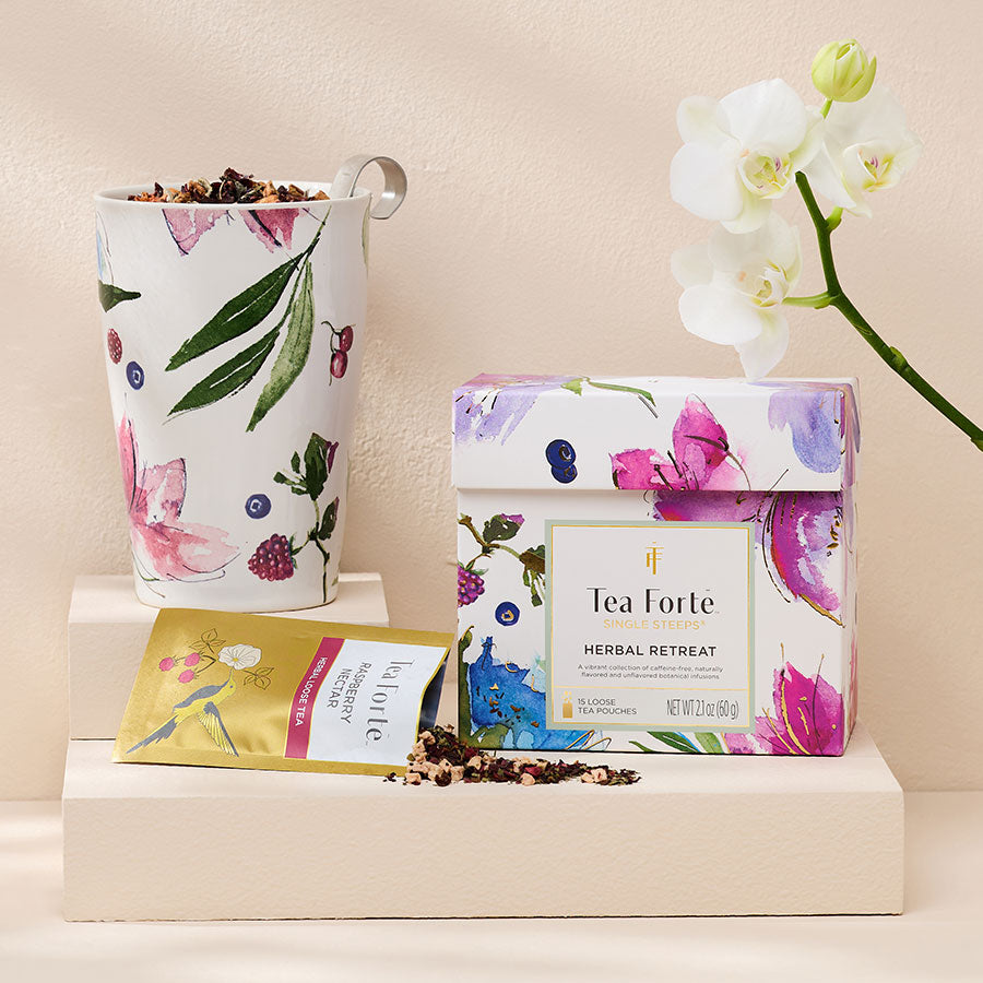 Herbal Retreat Single Steeps Sampler with a KATI Steeping Cup, a pouch open and a flower