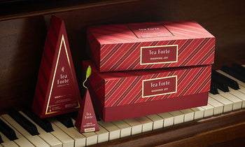 Warming Joy Presentation Boxes and a Petite Tea Tree on a piano