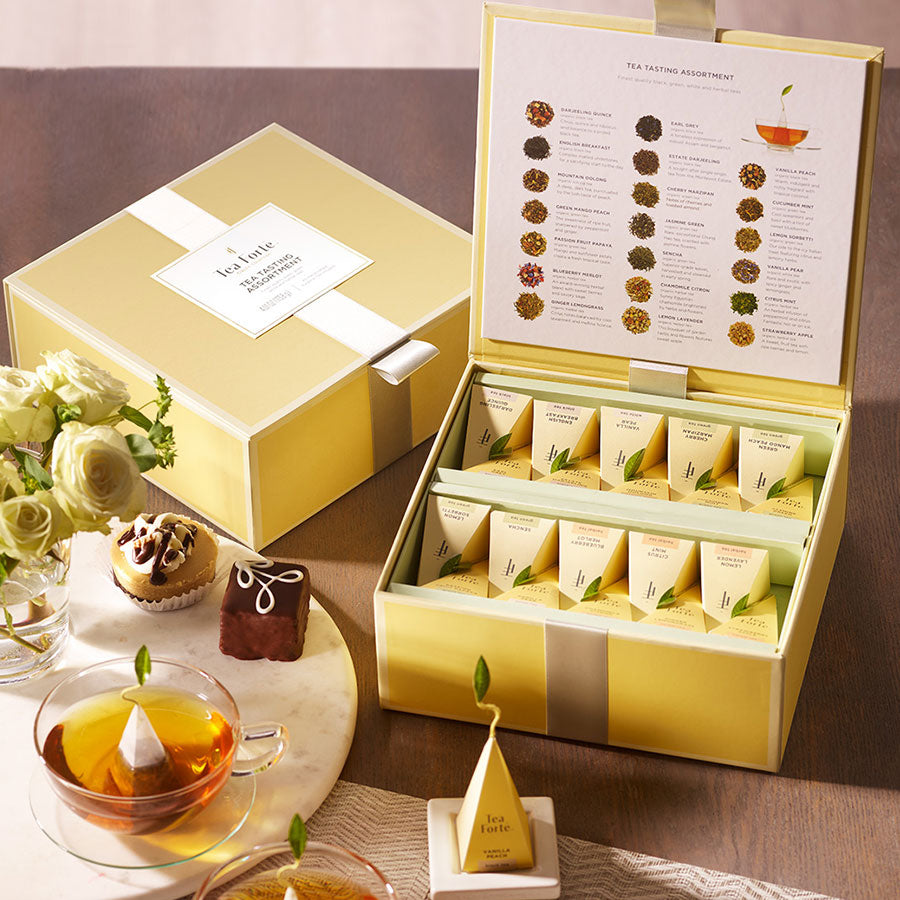 Tea Chest open with cups of tea and desserts