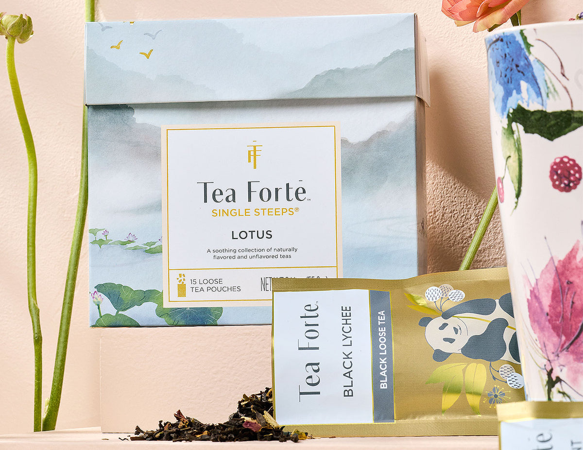 MAIN PDP | Lotus Single Steeps Sampler of 15 loose tea pouches, closed with pouch open in front and flowers