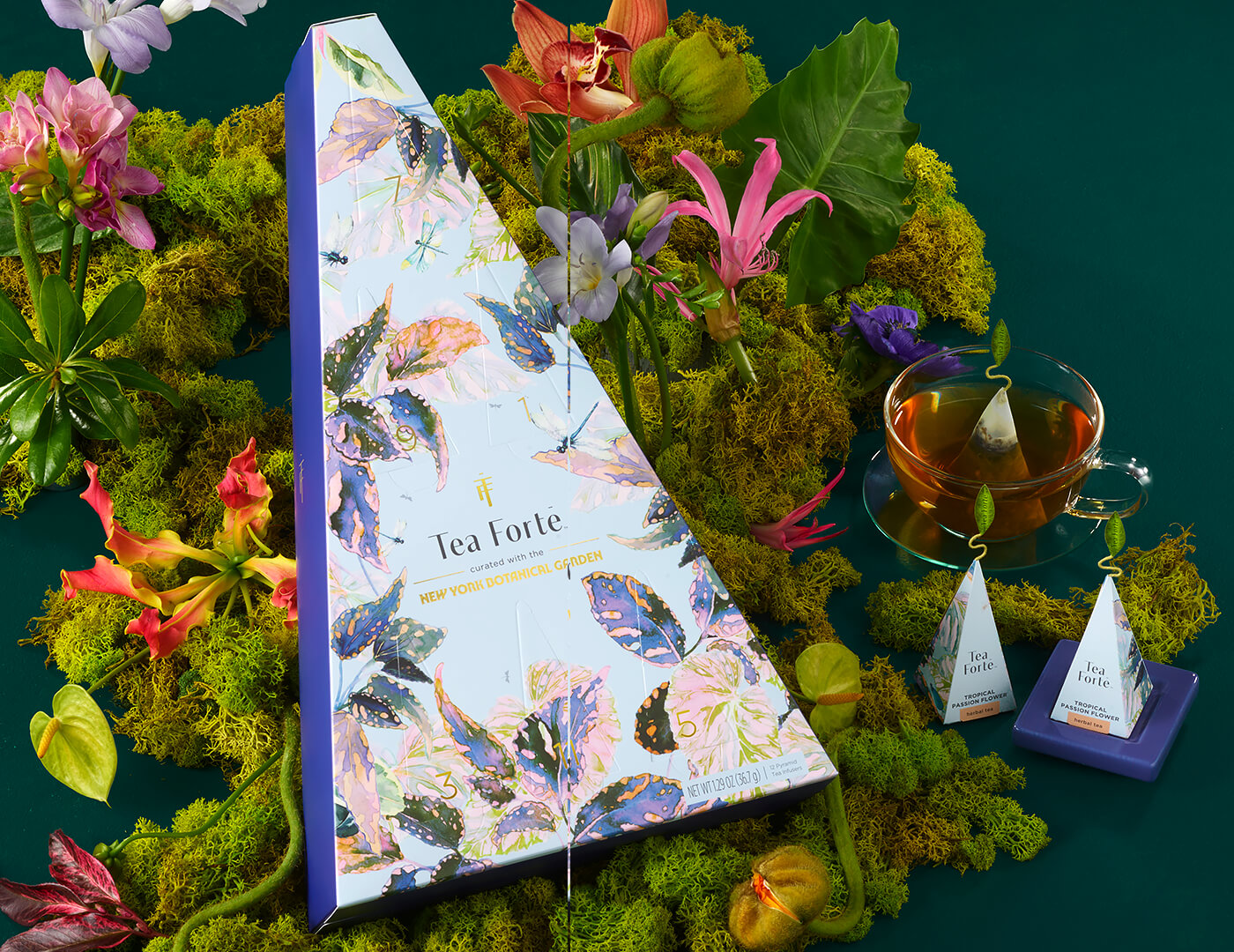 Demoiselle 12 days of Teas box with a teacup and tea infusers in a layer of moss and flowers