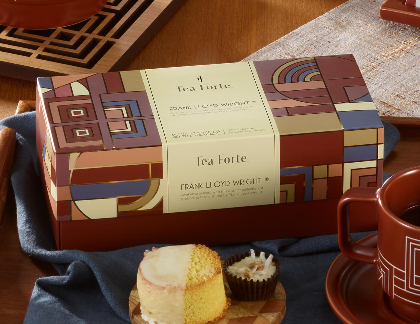 Frank Lloyd Wright Presentation Box,  closed on a table with dessert and teacup