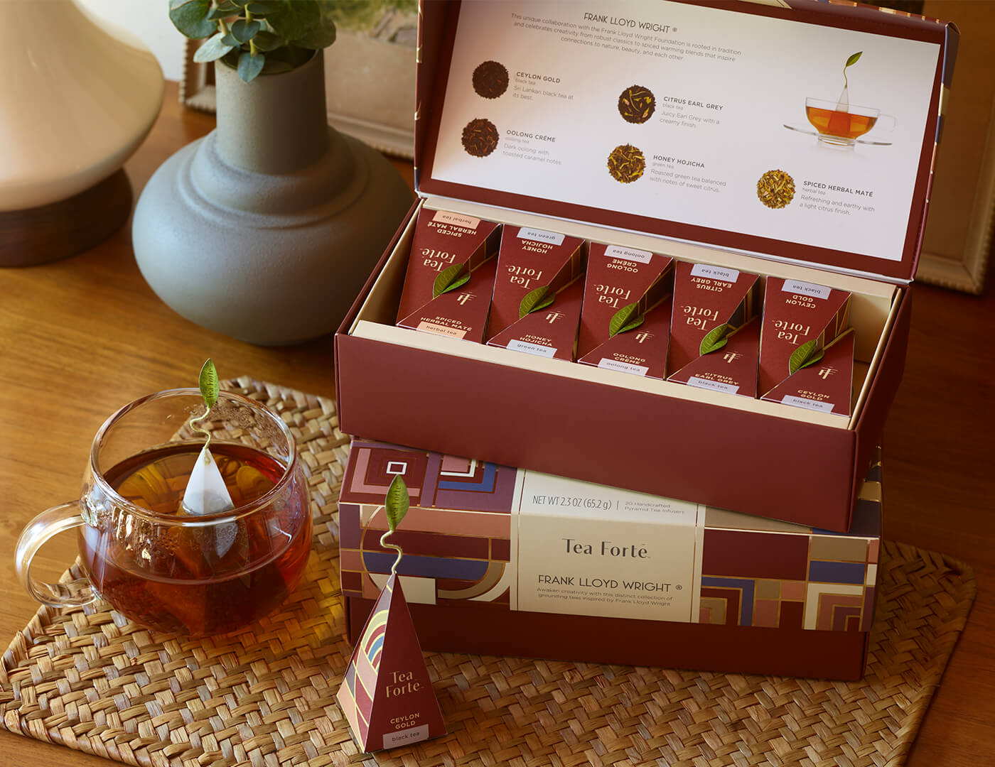 Frank Lloyd Wright Petite Presentation Box, open on table, stacked on top of a Presentation Box, with teacup and infuser