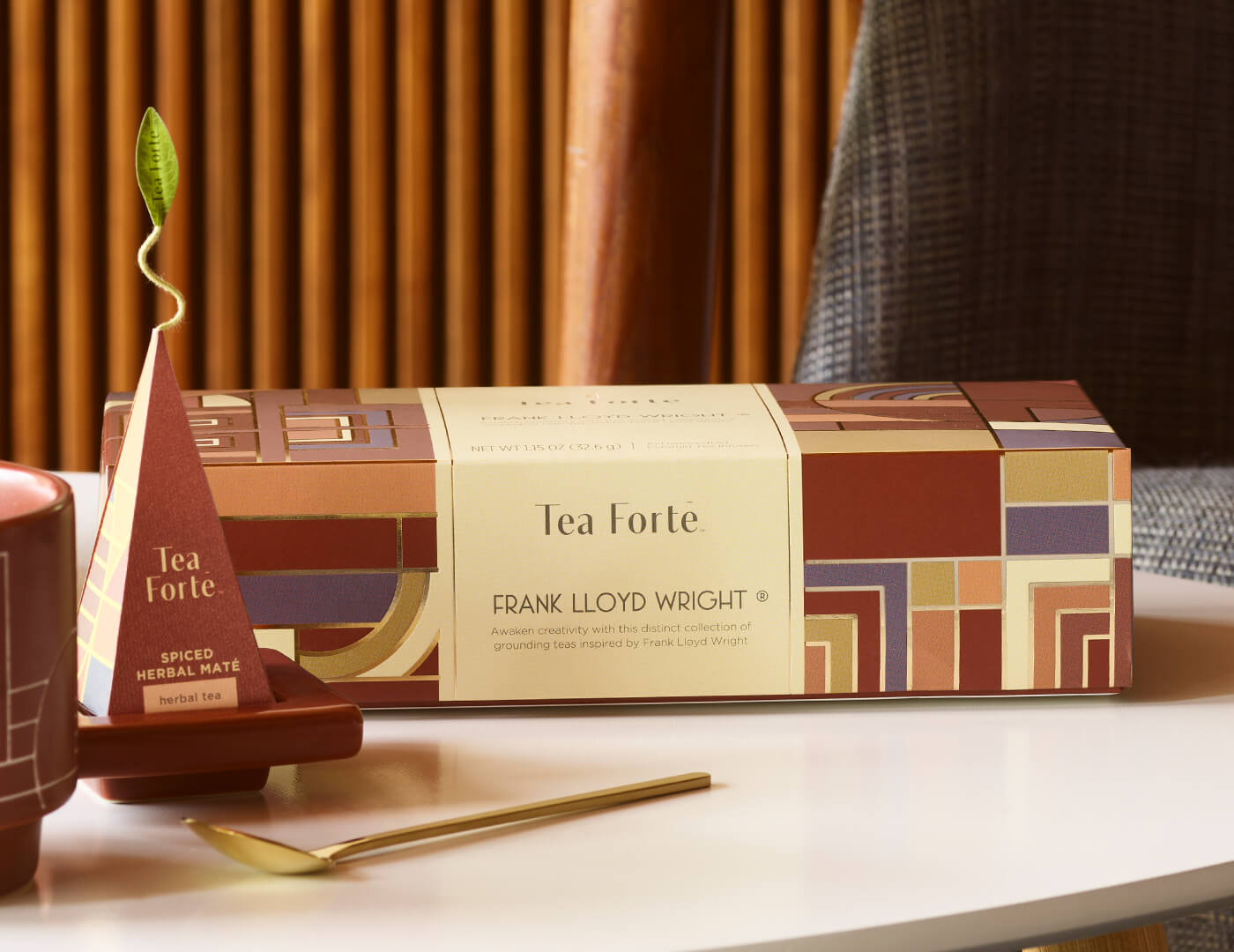 Frank Lloyd Wright Petite Presentation Box of 10 pyramid infusers and a infuser resting on a tray with gold spoon