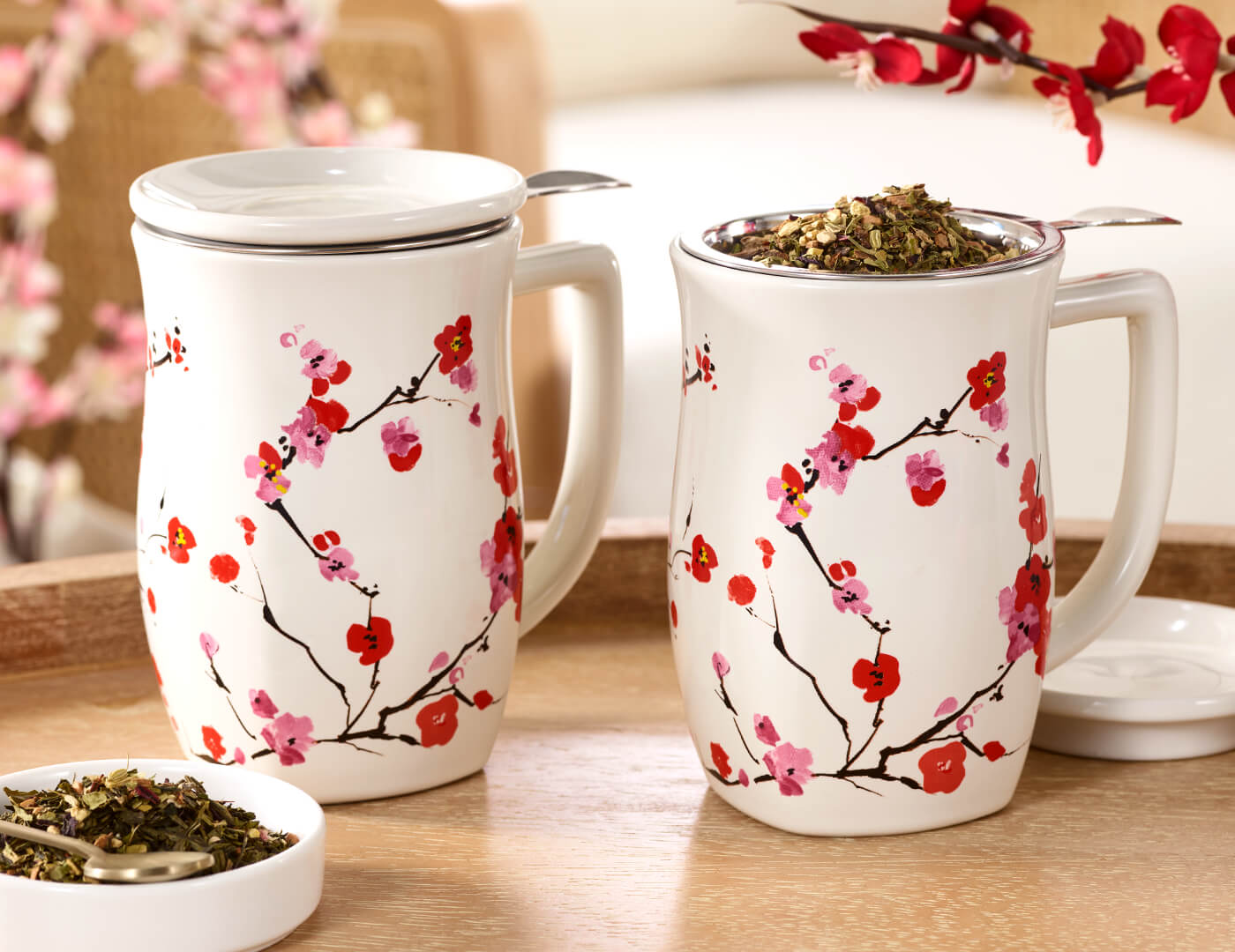 Two Fiore Sakura Steeping Cups, shown side by side, one with the lid on and one with the lid off and loose leaf tea inside the infuser