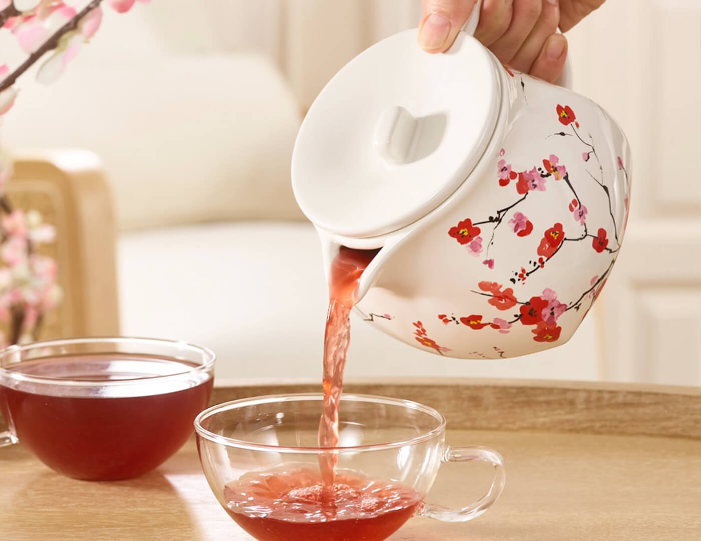 Sakura Fiore Teapot pouring tea into a glass cup