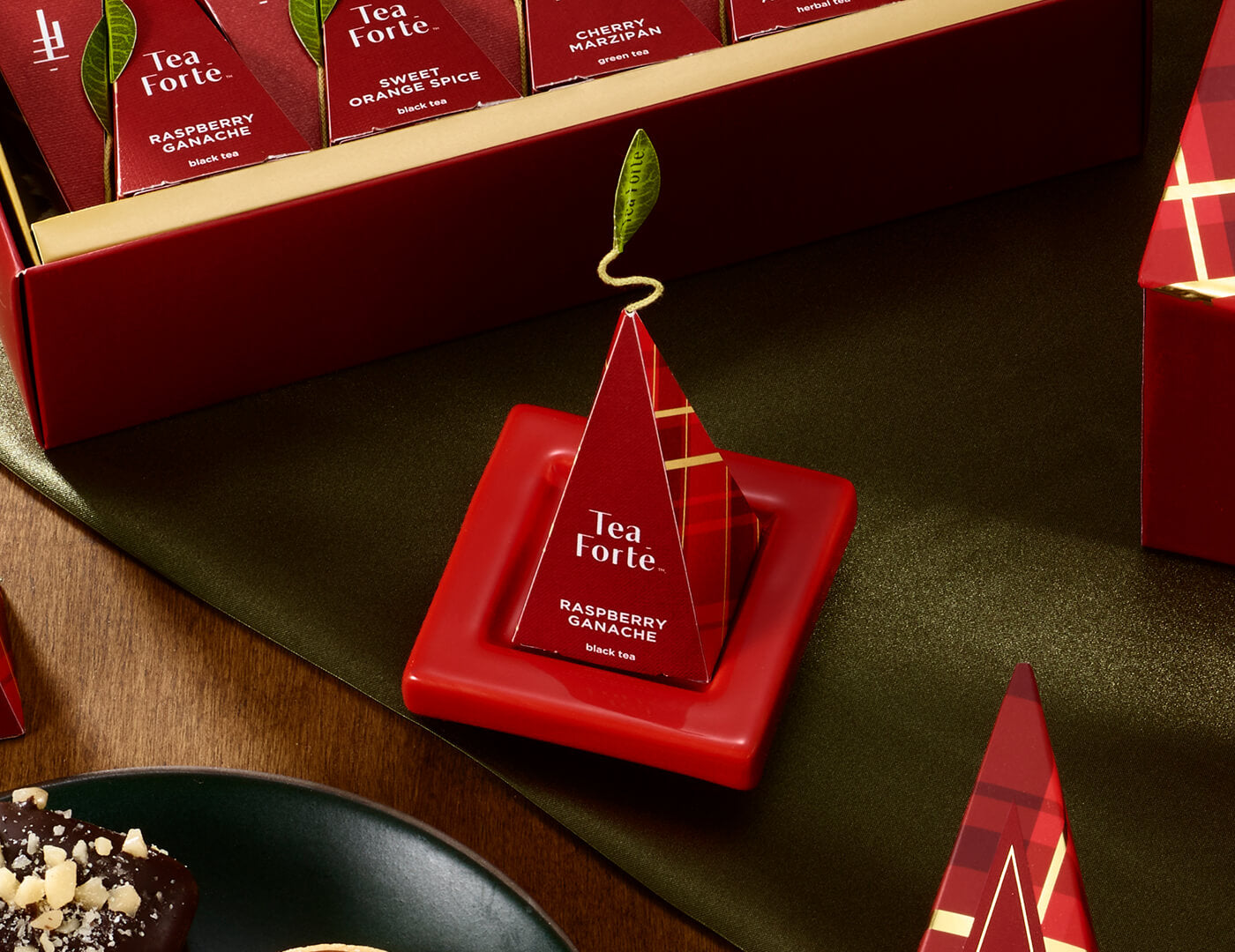Ruby Red Tea Tray with infuser perched on top resting on festive table with a Warming Joy Petite Box open