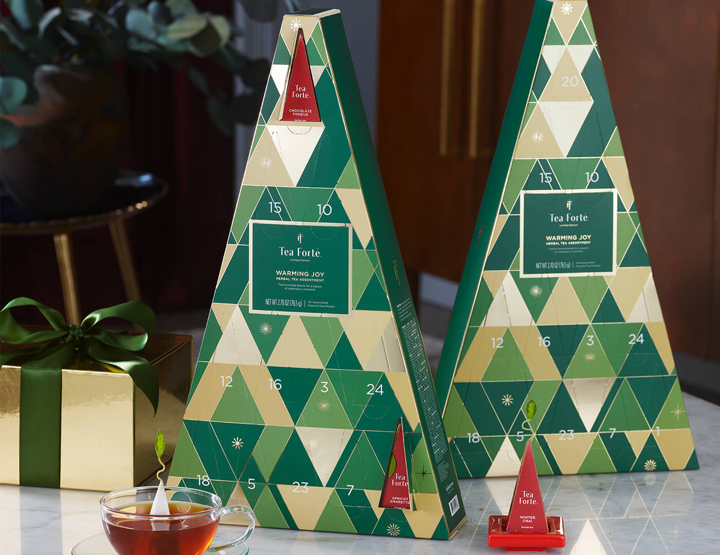 Two Warming Joy Herbal Advent Calendars with doors open and infusers to the right outside of box