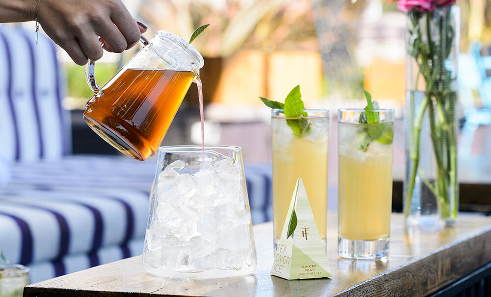 Tea Over Ice Pitcher Set, small pitcher of  brewed iced tea being poured into lower pitcher filled with ice.