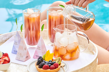 Pouring iced tea into a pitcher poolside with iced tea glasses and dessert