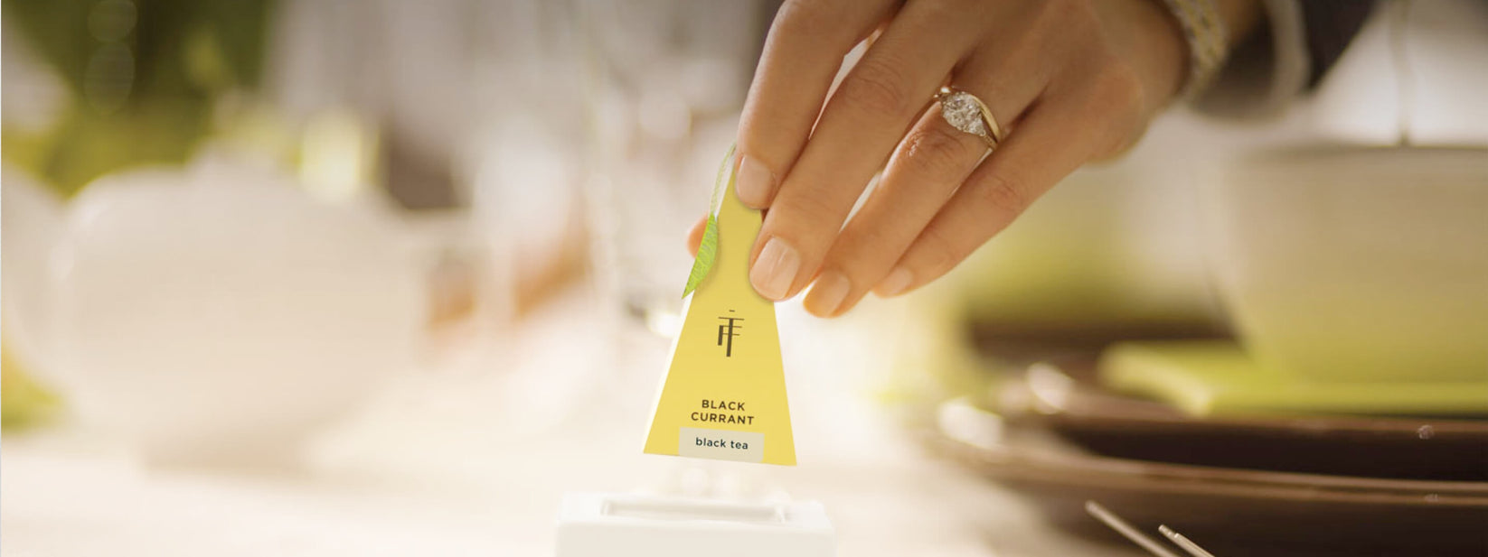 A Tea Forté pyramid infuser being placed into a cup
