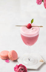 Raspberry Nectar Clover Club in a glass with pink macarons and pink roses