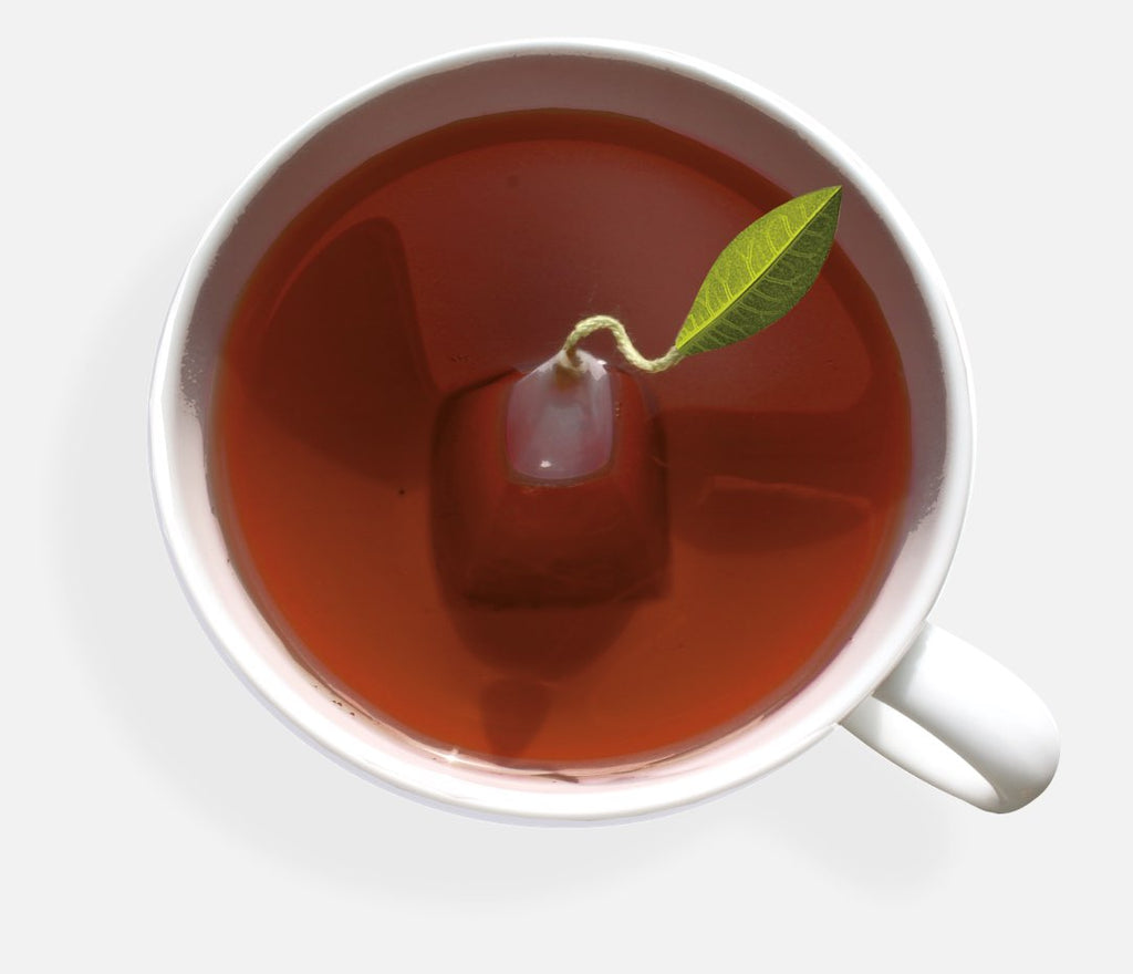 Café cup filled with tea and a pyramid infuser, seen from above